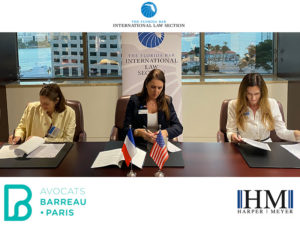 Harper Meyer Partner Jacqueline Villalba signing documentation along members of the Paris Bar Association.